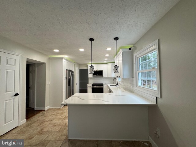 kitchen featuring kitchen peninsula, stainless steel appliances, sink, pendant lighting, and white cabinetry