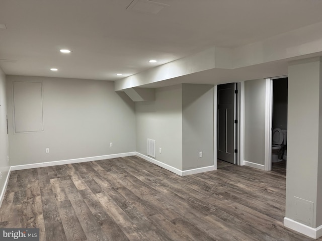 basement with dark hardwood / wood-style floors