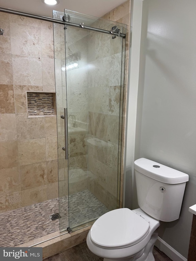 bathroom with hardwood / wood-style flooring, vanity, toilet, and a shower with shower door