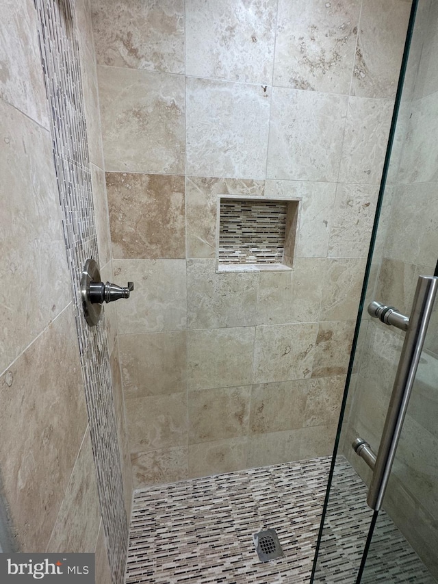 bathroom featuring a shower with door