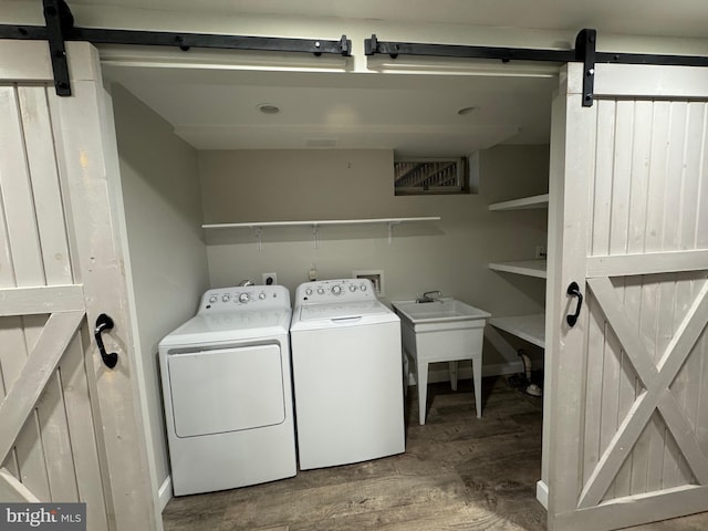 laundry area featuring a barn door, wood-type flooring, and independent washer and dryer