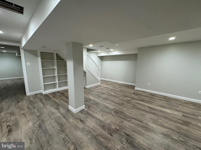 basement with dark hardwood / wood-style floors