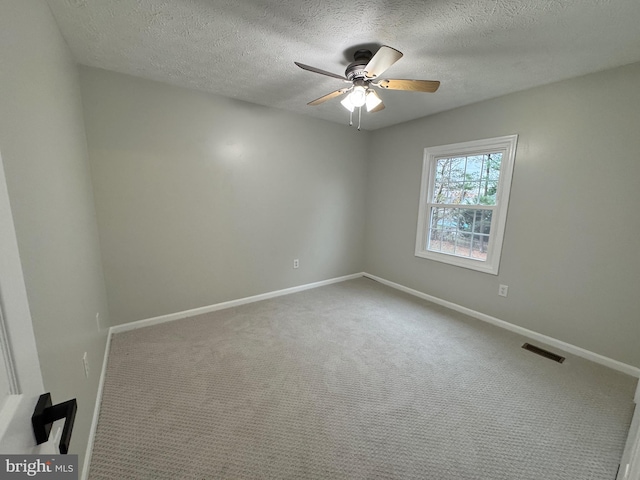 spare room featuring carpet, ceiling fan, and a textured ceiling