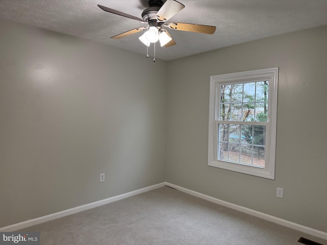 empty room featuring ceiling fan, carpet floors, and a textured ceiling