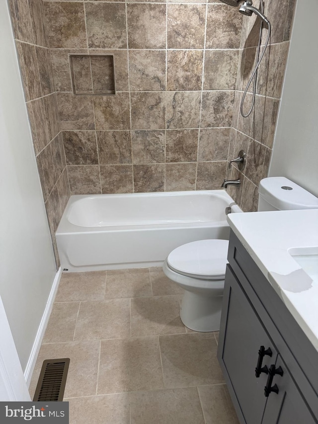 full bathroom with tile patterned floors, vanity, toilet, and tiled shower / bath combo