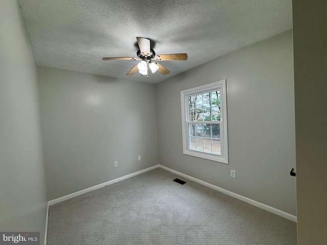 carpeted spare room with ceiling fan and a textured ceiling