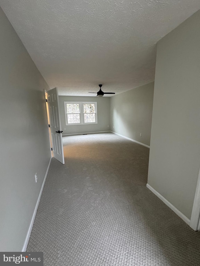 spare room with carpet, a textured ceiling, and ceiling fan