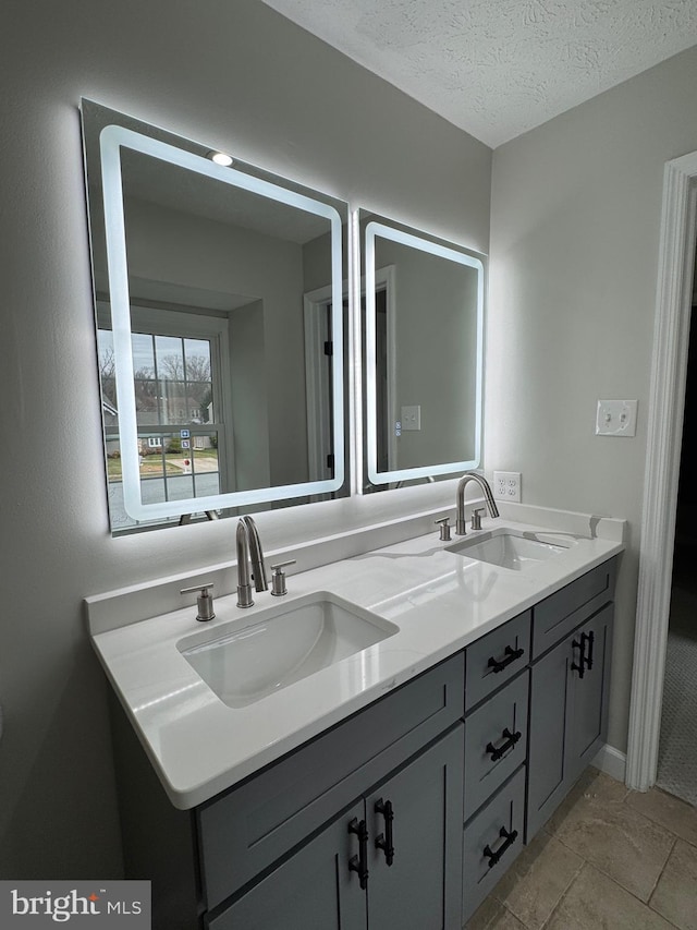 bathroom with tile patterned floors, vanity, and a textured ceiling