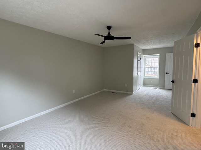 carpeted spare room with ceiling fan and a textured ceiling