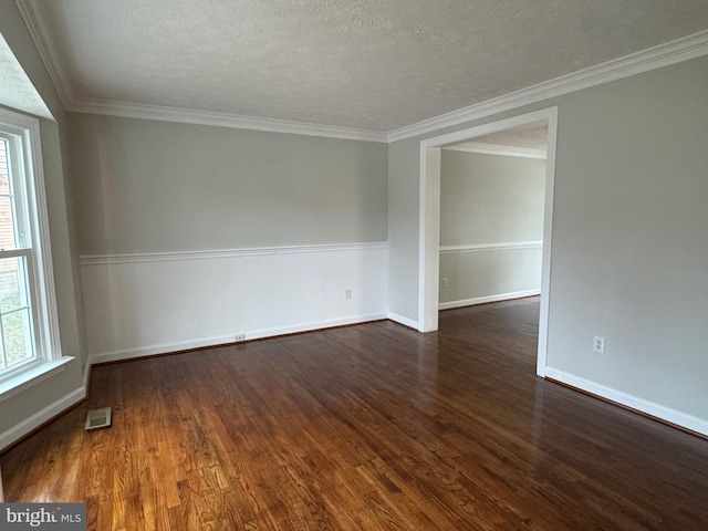 spare room with a textured ceiling, dark hardwood / wood-style floors, and crown molding