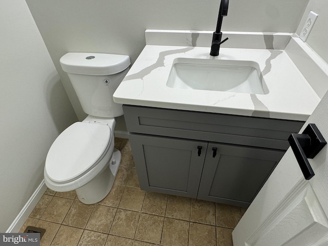 bathroom with tile patterned flooring, vanity, and toilet