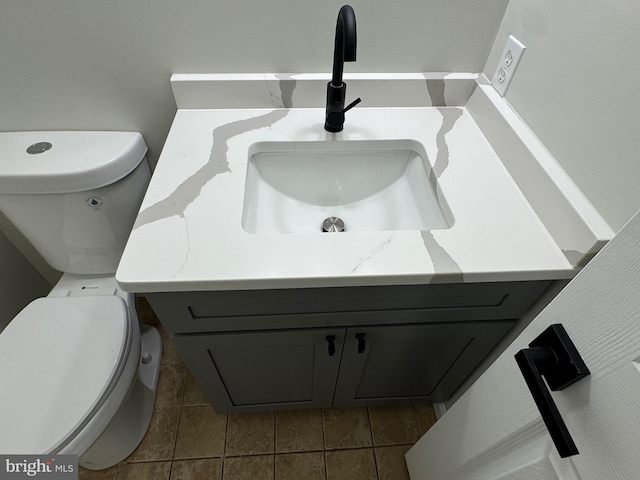 bathroom featuring tile patterned flooring, vanity, and toilet