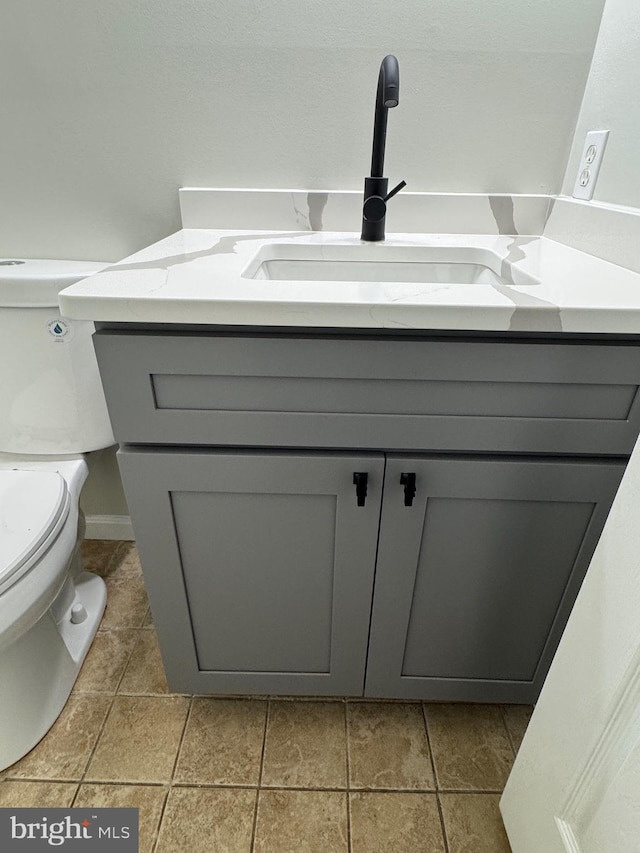 bathroom featuring tile patterned flooring, vanity, and toilet