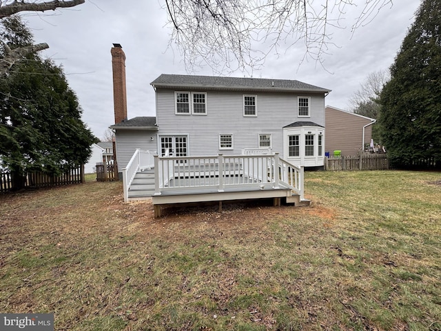 rear view of property with a lawn and a wooden deck