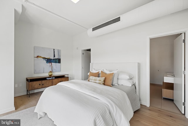 bedroom with visible vents, baseboards, and light wood-style flooring