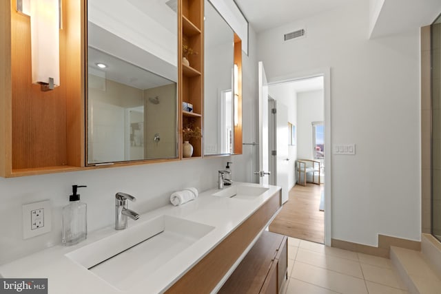 bathroom with an enclosed shower, visible vents, tile patterned flooring, and a sink