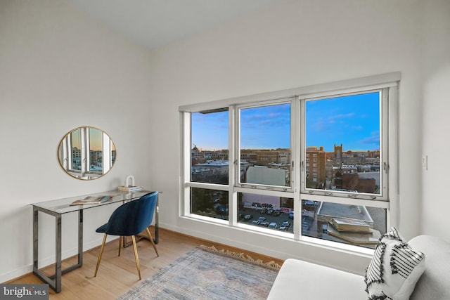 home office featuring baseboards, a view of city, and wood finished floors