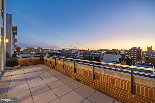 patio terrace at dusk with a city view and a balcony