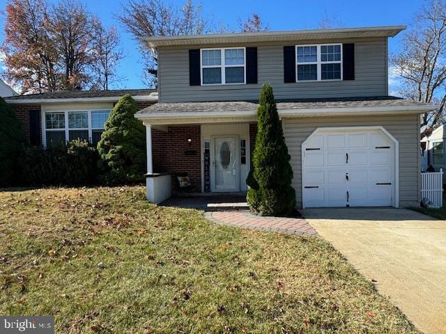 view of property with a garage and a front lawn