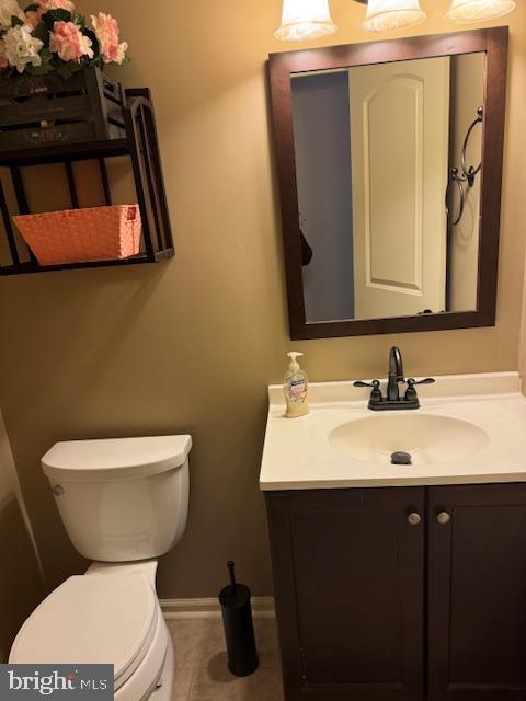 bathroom featuring tile patterned flooring, vanity, and toilet