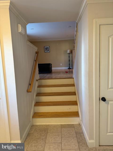 stairs featuring tile patterned flooring and ornamental molding