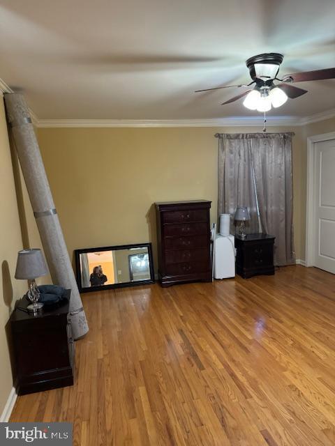 unfurnished bedroom featuring light hardwood / wood-style flooring, ceiling fan, and crown molding