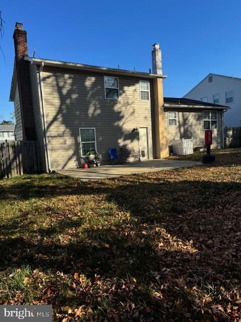 rear view of house featuring a patio area and a yard