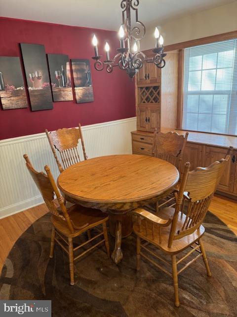 dining space with light hardwood / wood-style flooring and a notable chandelier