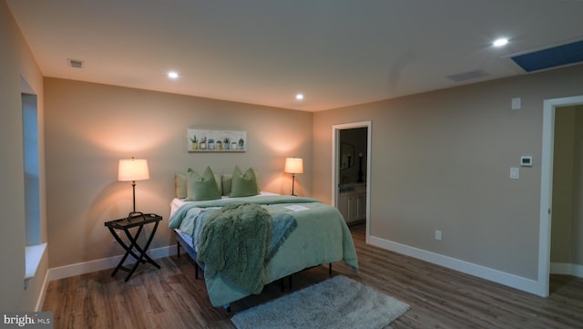 bedroom featuring dark hardwood / wood-style flooring and ensuite bath