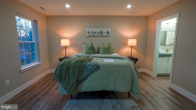 bedroom with ensuite bathroom and wood-type flooring