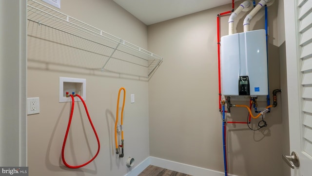 laundry room featuring hookup for a washing machine, tankless water heater, and hardwood / wood-style flooring