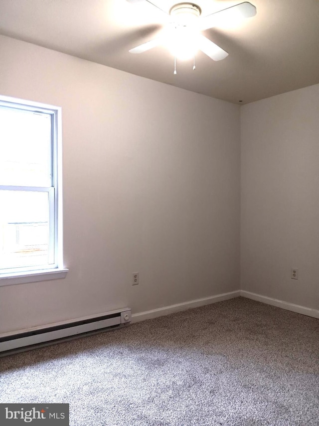 carpeted empty room with a wealth of natural light, ceiling fan, and a baseboard radiator