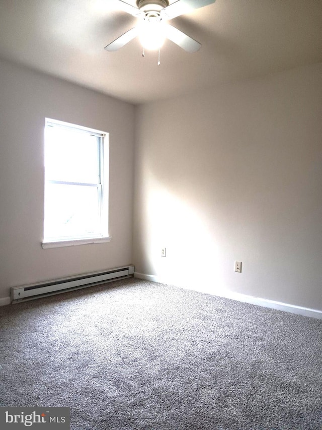 carpeted empty room featuring ceiling fan and a baseboard heating unit