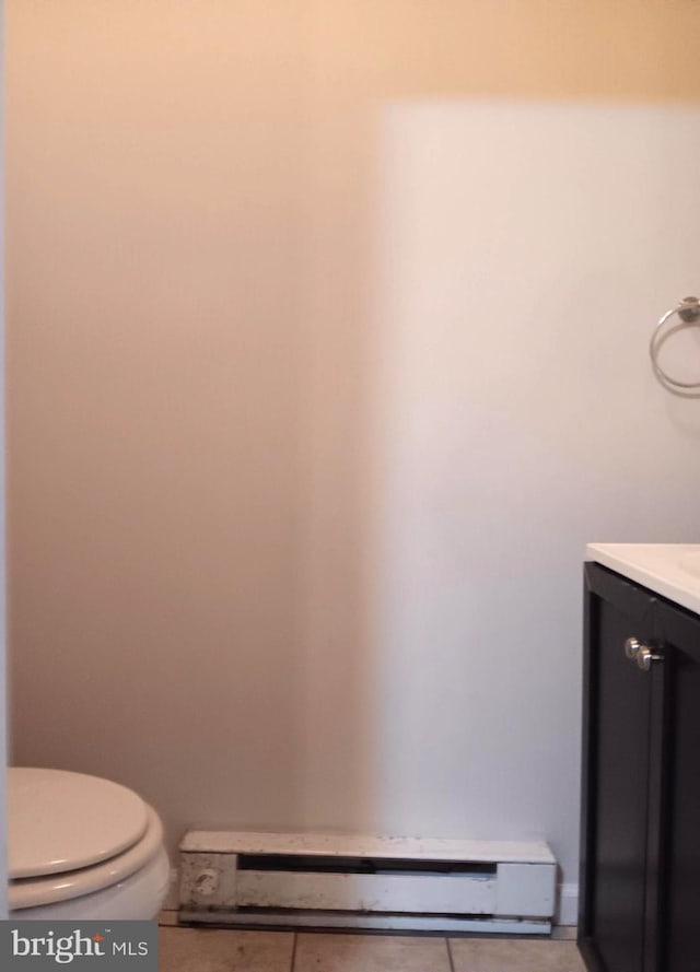 bathroom featuring tile patterned flooring, vanity, toilet, and a baseboard heating unit