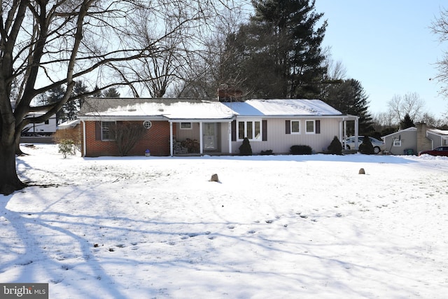 view of snow covered back of property