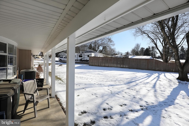 snow covered patio featuring central air condition unit