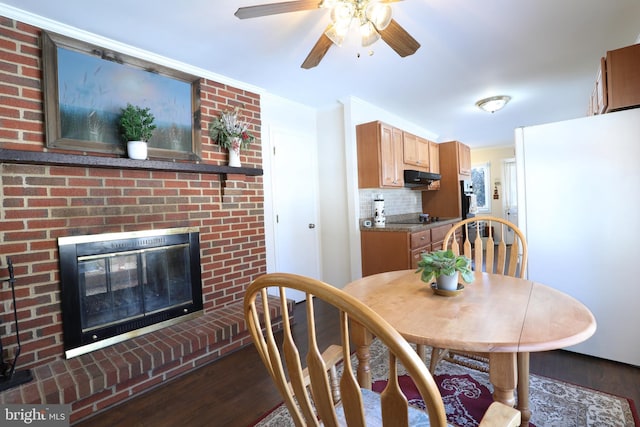 dining area with a brick fireplace and dark hardwood / wood-style floors