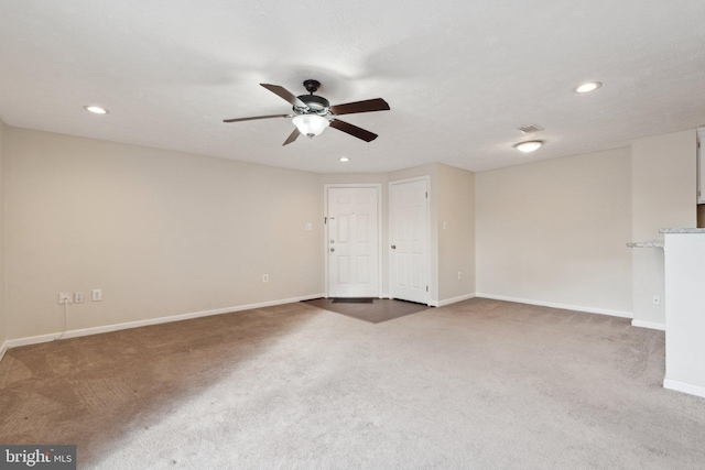 spare room with dark colored carpet, ceiling fan, and a textured ceiling