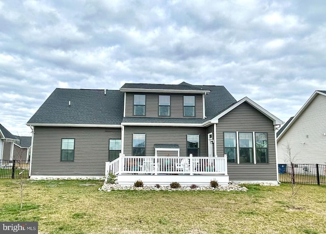 rear view of property featuring a deck and a lawn