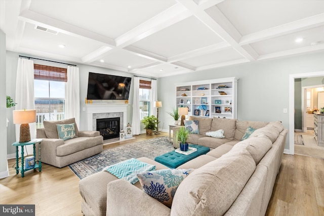 living room featuring coffered ceiling, a wealth of natural light, and light hardwood / wood-style flooring