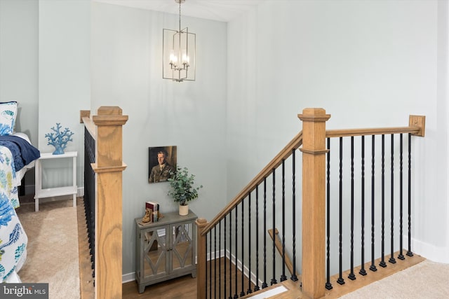 stairway with a notable chandelier