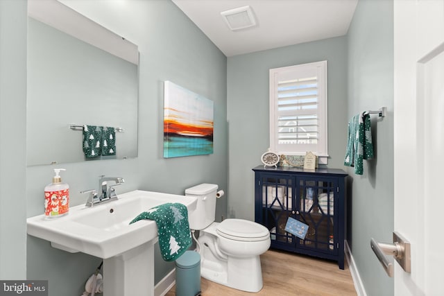 bathroom featuring wood-type flooring and toilet