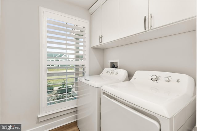 washroom featuring cabinets and washing machine and clothes dryer