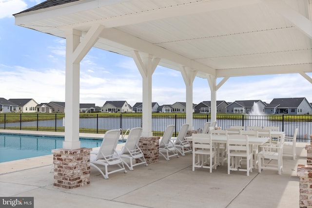 view of patio / terrace featuring a community pool and a water view