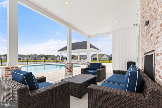 view of patio / terrace with a fenced in pool, a gazebo, and an outdoor hangout area