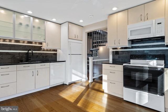 kitchen featuring backsplash, dark hardwood / wood-style floors, white appliances, and sink