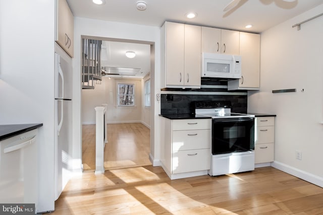 kitchen featuring white cabinets, light hardwood / wood-style floors, white appliances, and tasteful backsplash