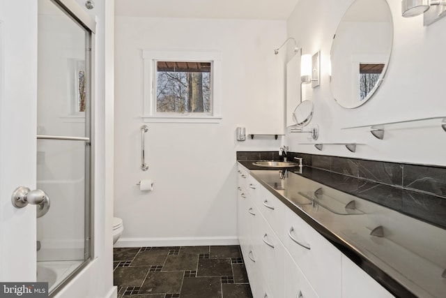 full bathroom with vanity, toilet, and bath / shower combo with glass door