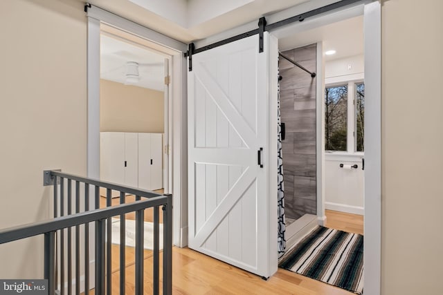 interior space with a barn door and wood-type flooring