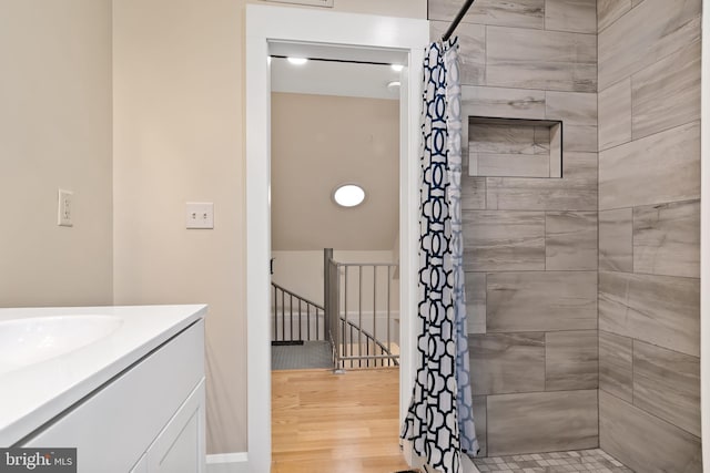 bathroom featuring vanity, wood-type flooring, and walk in shower